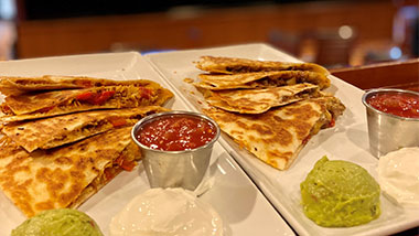Two orders of quesadillas, one chicken quesadilla and a philly quesadilla